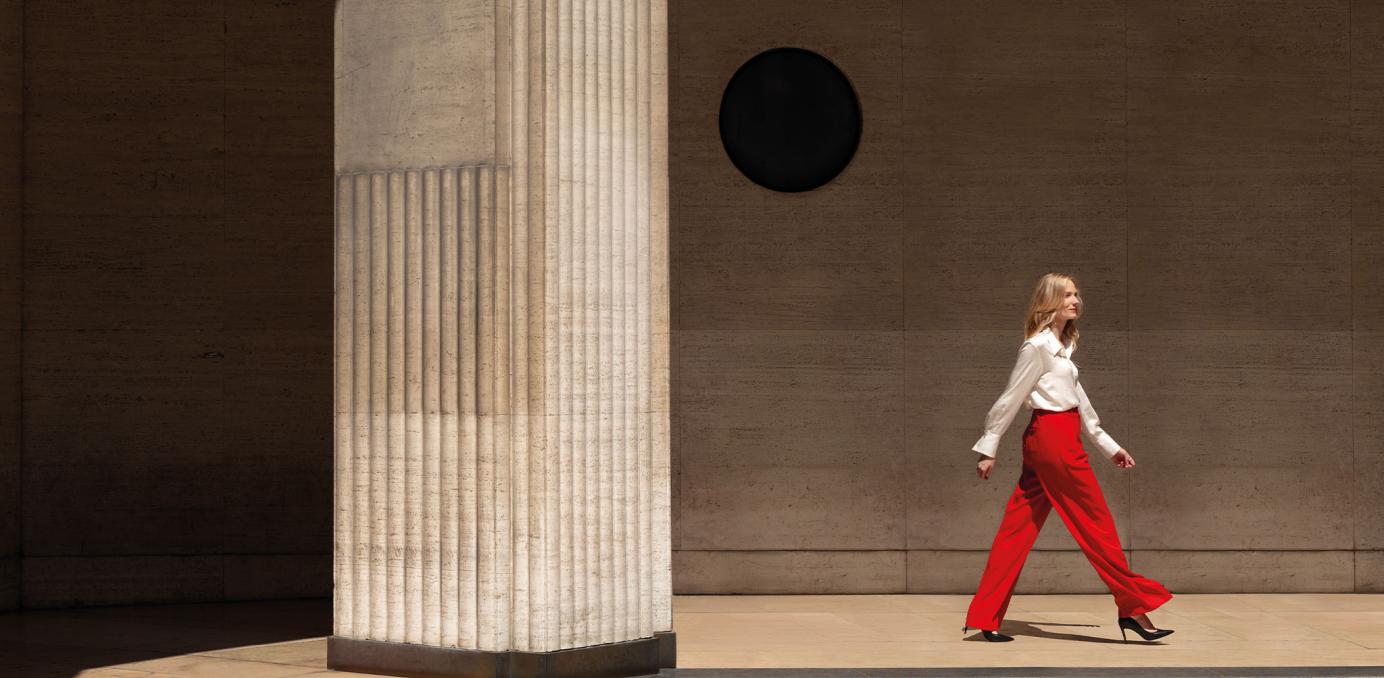 The corporate visual features a woman walking confidently at Place Vendome in Paris