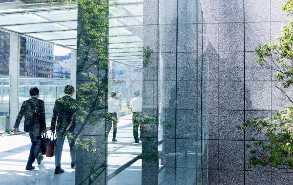 Two employees walking inside a glass building